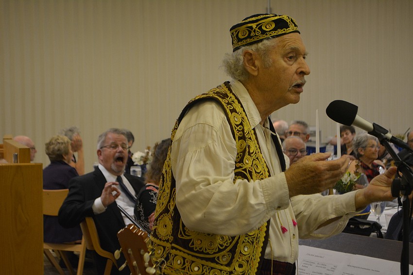 Juan De la Sierra (foreground), dressed in the style of an early-20th century western-Turkish Sephardi, sings a song Friday night at Temple Beth Israel. TBI Rabbi Stephen Sniderman (background, left) sings along.