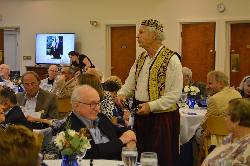 Juan De la Sierra (standing) walks through the audience while performing a song that involves zills, or finger cymbals, Friday night at Temple Beth Israel.