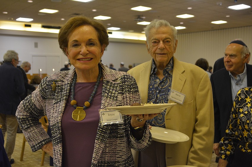 Joyce Cooper (left) and Marvin Morse (right) wait to be served during a Sephardic-style feast Friday night at Temple Beth Israel.