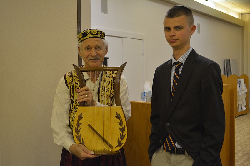 Juan De la Sierra (left) shows a replica of a King David harp to Spencer Sniderman (right) on Friday night at Temple Beth Israel.