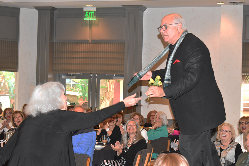Sylvia Pastor hands flowers to Isaac Azerad.
