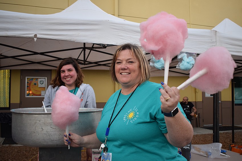 Lauren Agabi and Keri Moritz, third grade teachers, pass out cotton candy. Moritz says she likes the family-fun atmosphere of Winter Wonderland.