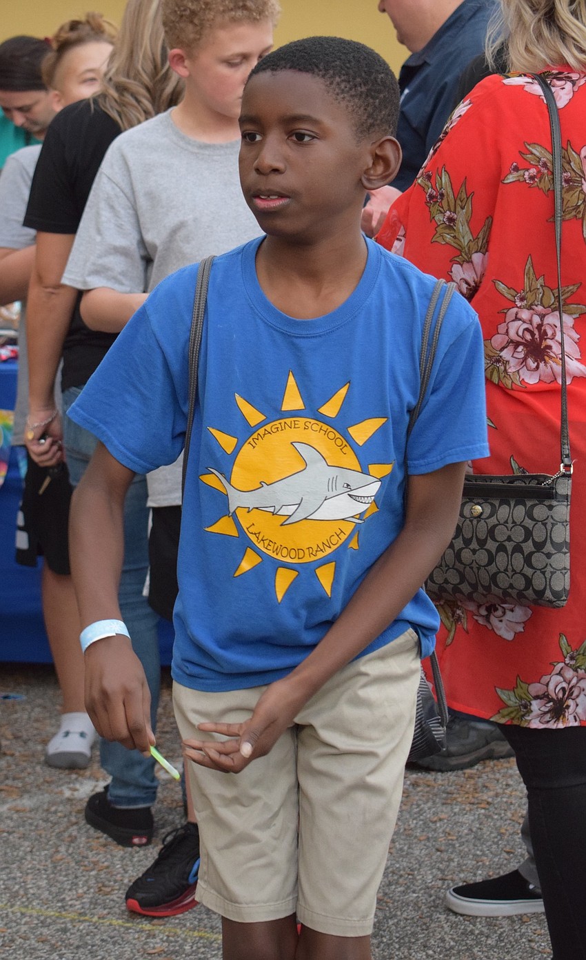 Omarien Watson, a sixth grader, attempts to toss a ring over a one-liter bottle of soda to win a bottle. Watson tried four times to win.