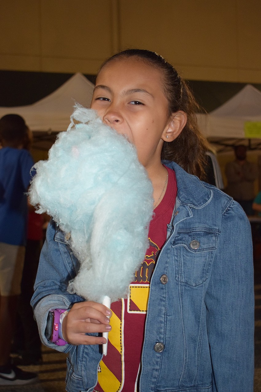 Valentina Sanchez, a fourth grader, takes a big bite of her cotton candy. Sanchez says besides the cotton candy, she enjoyed the bungee trampoline because she was 