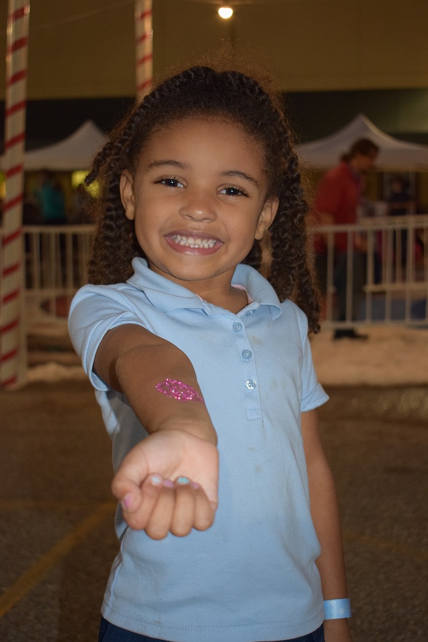 Kiyah Higdon, a pre-kindergartner, shows off her pink glitter diamond tattoo. Higdon chose a diamond because she loves diamonds. 