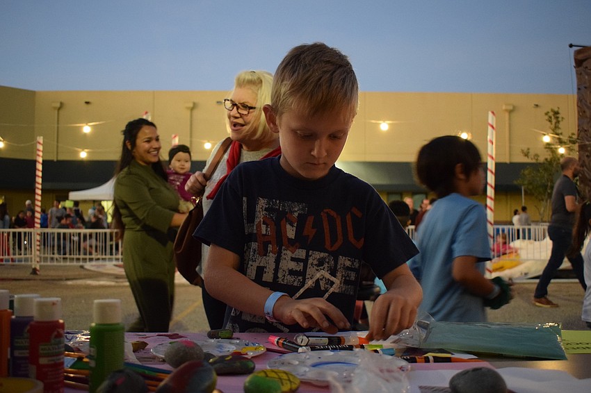 Tayton Melancon paints a rock during Winter Wonderland. His brother, Kai, a third grader, wanted his family to come to his school event.