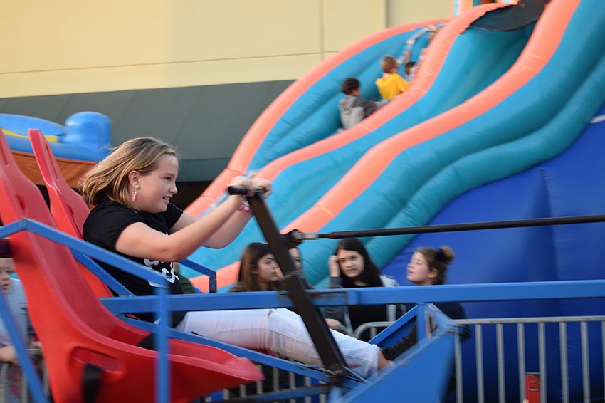 Emilee Moore pulls down a level on a tug-of-war ride. Moore says she liked pulling the lever to control the speed.
