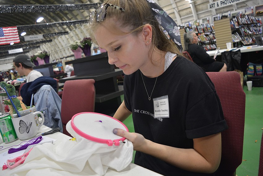 Palmetto's Brandie Teachey was in the arts and crafts hall to demonstrate painting. While waiting for visitors, she took up cross stitch.