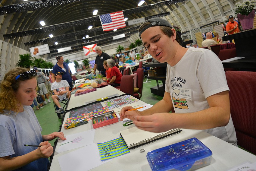 Dr. Mona Jain Middle School's Sadie Henderson tries her hand at drawing a flower under the guidance of artist David Correia.