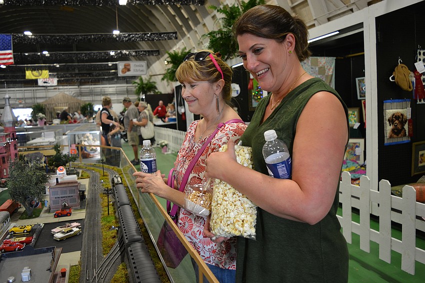 Palmetto's D.J. Cromwell and Heather McBride volunteered to cut strawberries for strawberry shortcakes sold by their church, Church on the Rock. Afterward, they checked out the arts and crafts exhibition hall.