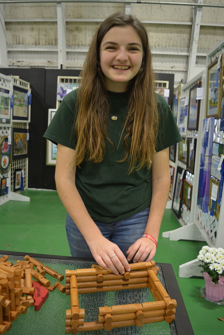 Palmetto's Elsie Hattaway mans a table of Lincoln Logs guests can use to build a masterpiece in the arts and crafts exhibition hall.