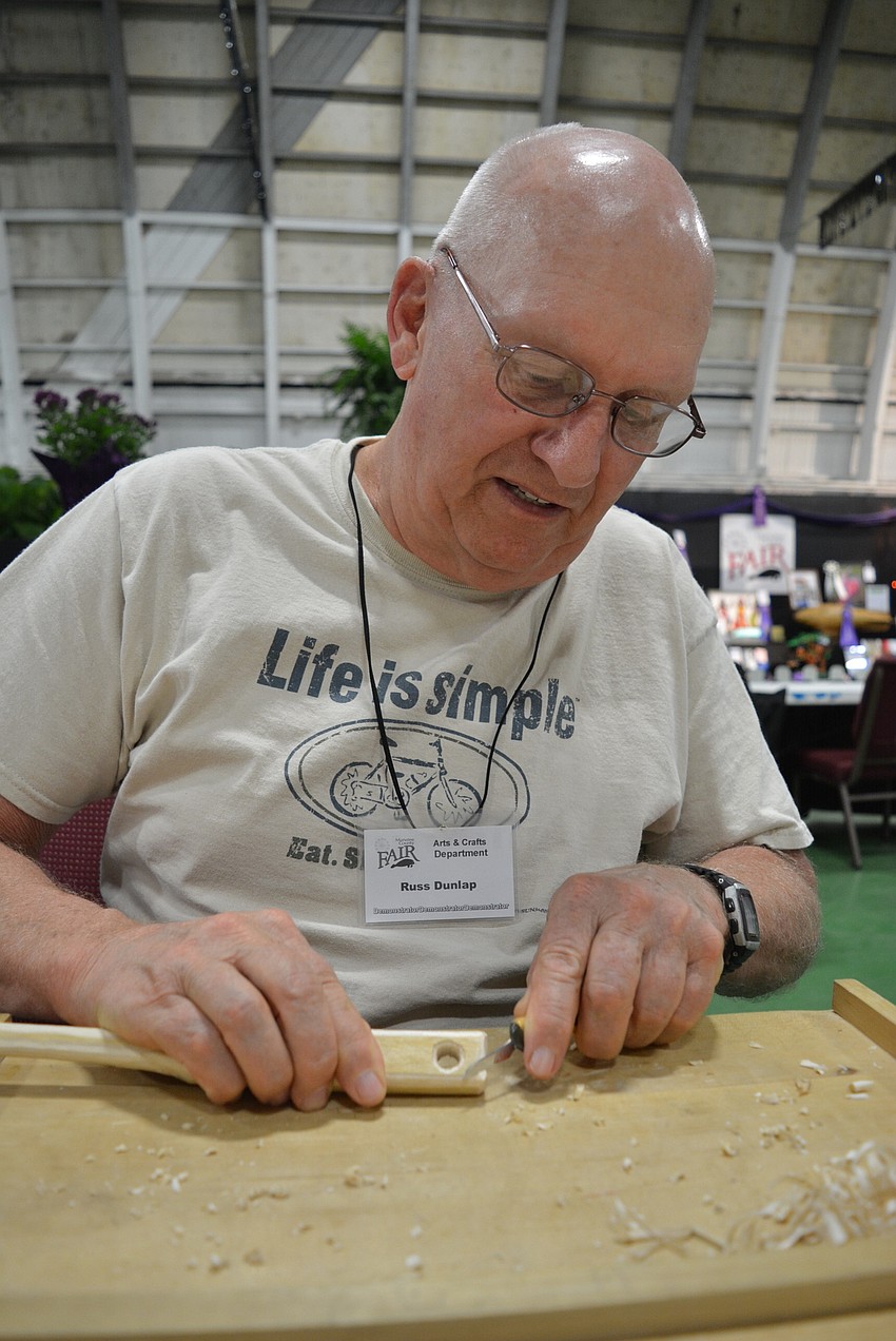 Russ Dunlap demonstrates woodworking for visitors to the arts and crafts hall. He tapers the edge of a shoehorn with ease.