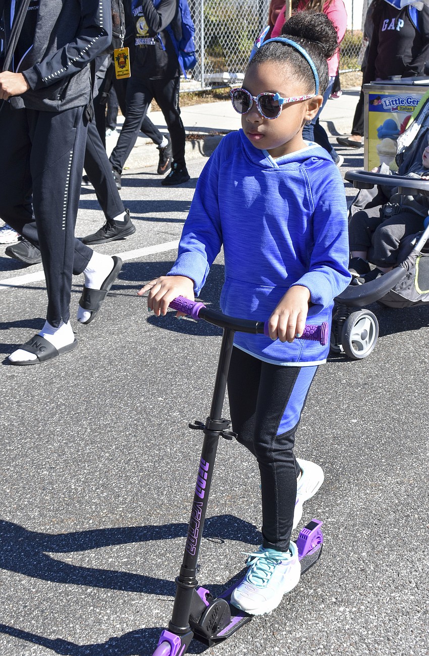 Geneis Williams, 6, rides her scooter during the walk.