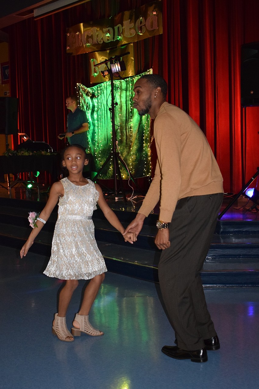 Ali'yana Jones, a third grader, dances with her dad, Donald, at the annual father-daughter dance. Donald Jones says they go to the dance every year and always have a great time.