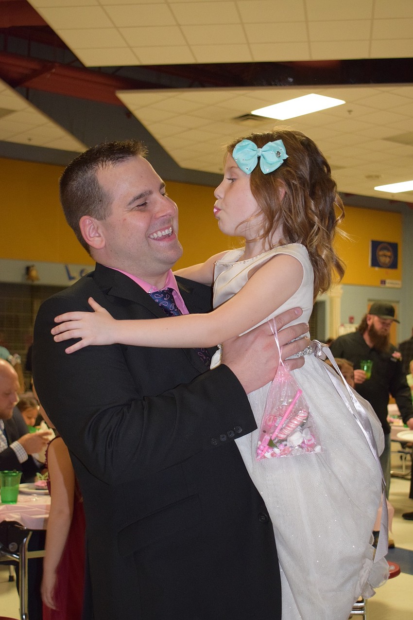 Jason Kinsman holds his daughter Addison, a kindergartner, while dancing to a slow song. This year's dance was the Kinsmans second. 