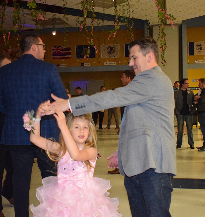 Scarlett Hafner, a first grader, is twirled around by her father, Mark. Scarlett Hafner says the dance is fantastic because you can dance.