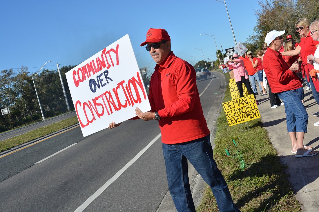 GreyHawk Landing&#39;s Jack Ranalli waved signs to oppose a proposal for a car dealership at the corner of 117th Street East and State Road 64.