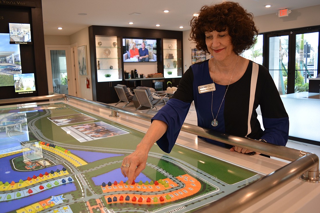 Cresswind at Lakewood Ranch Community Sales Manager Rhonda Fleming-Hill adds another "sold" home icon to a map of the community displayed in its information center.