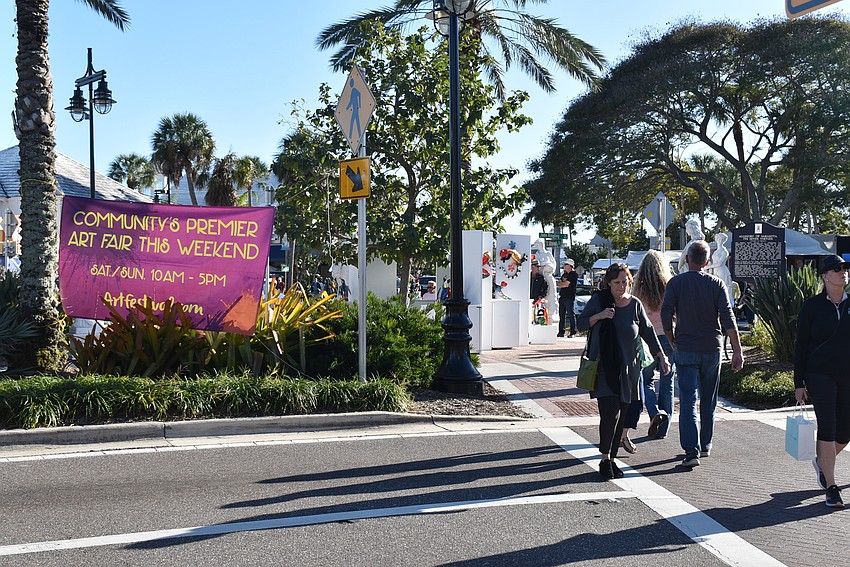 Attendees cross the street to and from the art festival.