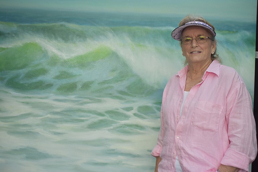 Lynda Kodwyck stands in front of her largest seascape.
