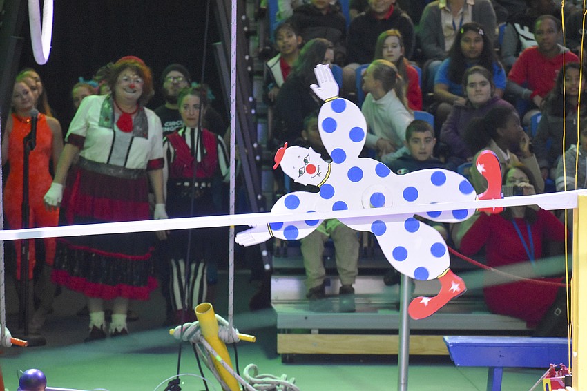 A wooden clown works it way to kick a ball to start the next chain reaction.