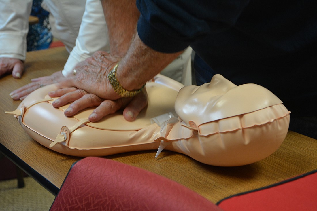 An attendee practices giving hands-only CPR on a dummy Jan. 23 at the Longboat Key fire station.