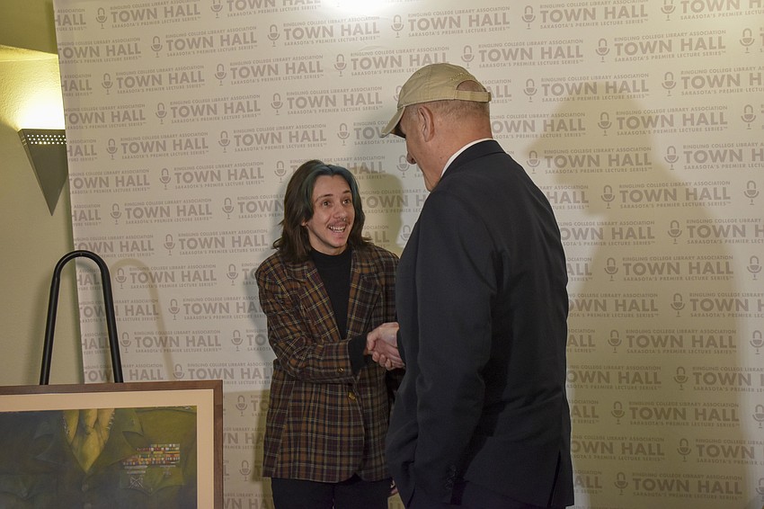 Ringling College of Art and Design student Oliver Stephenson presents John Kelly with a portrait of his Marines uniform.