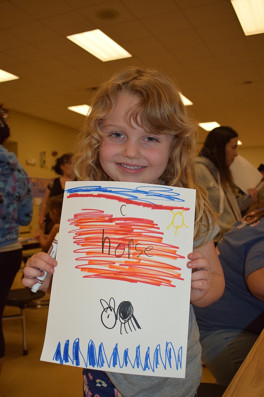 Casey Parker, a kindergartner, shows off her book cover illustration. 
