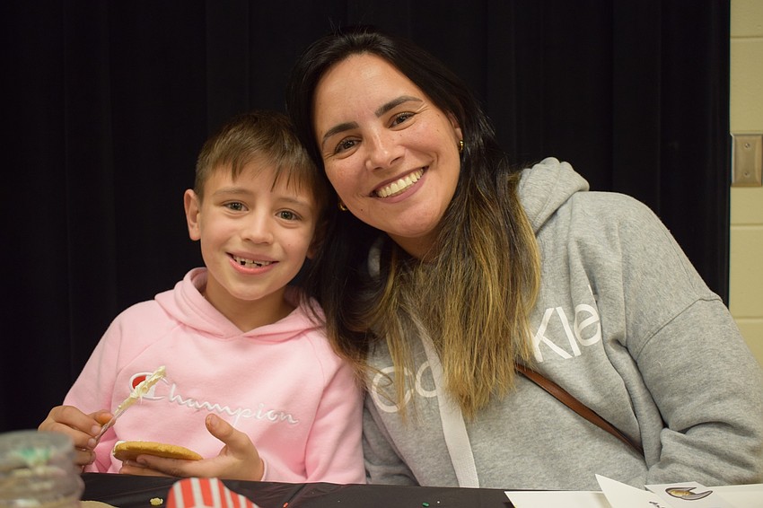 Thomas Cidral, a second grader, decorates a cookie with his mother, Lorena. The cookie decorating activity corresponded to a read aloud of 