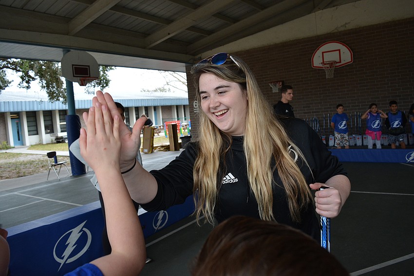 Lightning XXXX Victoria Santello energizes students with high fives before they step into the rink for a scrimmage game.