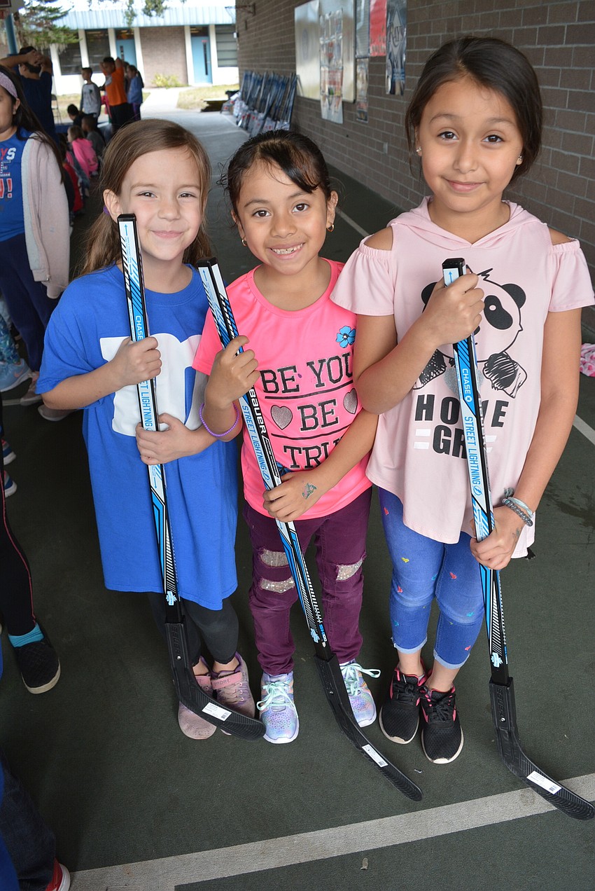 Second graders Lisa Chupp, Tifany Munoz and Crystal Ramos were excited they each got to take home a new hockey stick and ball.