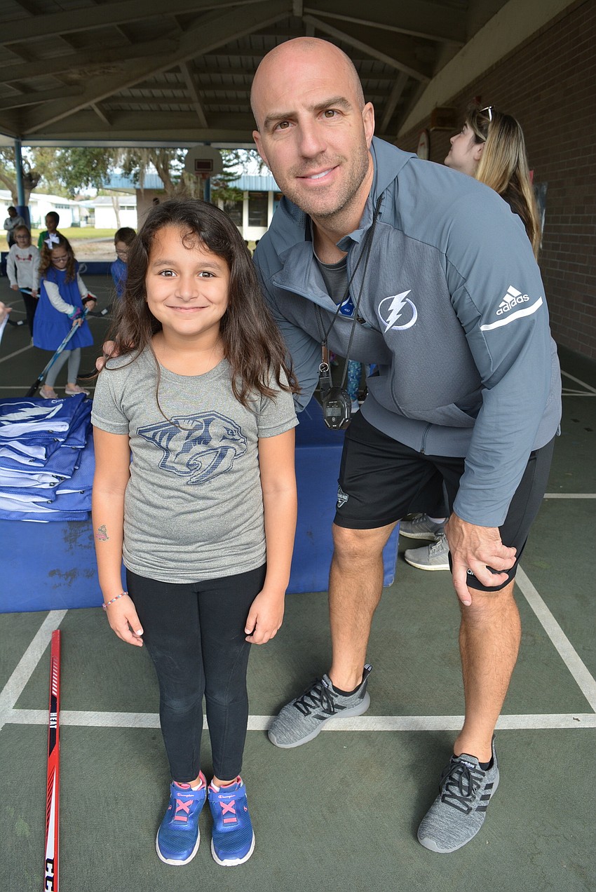 Third grader Analeigh Bailey was thrilled to pose for a picture with retired professional hockey player Mathieu Garon. She wanted his autograph, too, for her dad, Billy Smith.