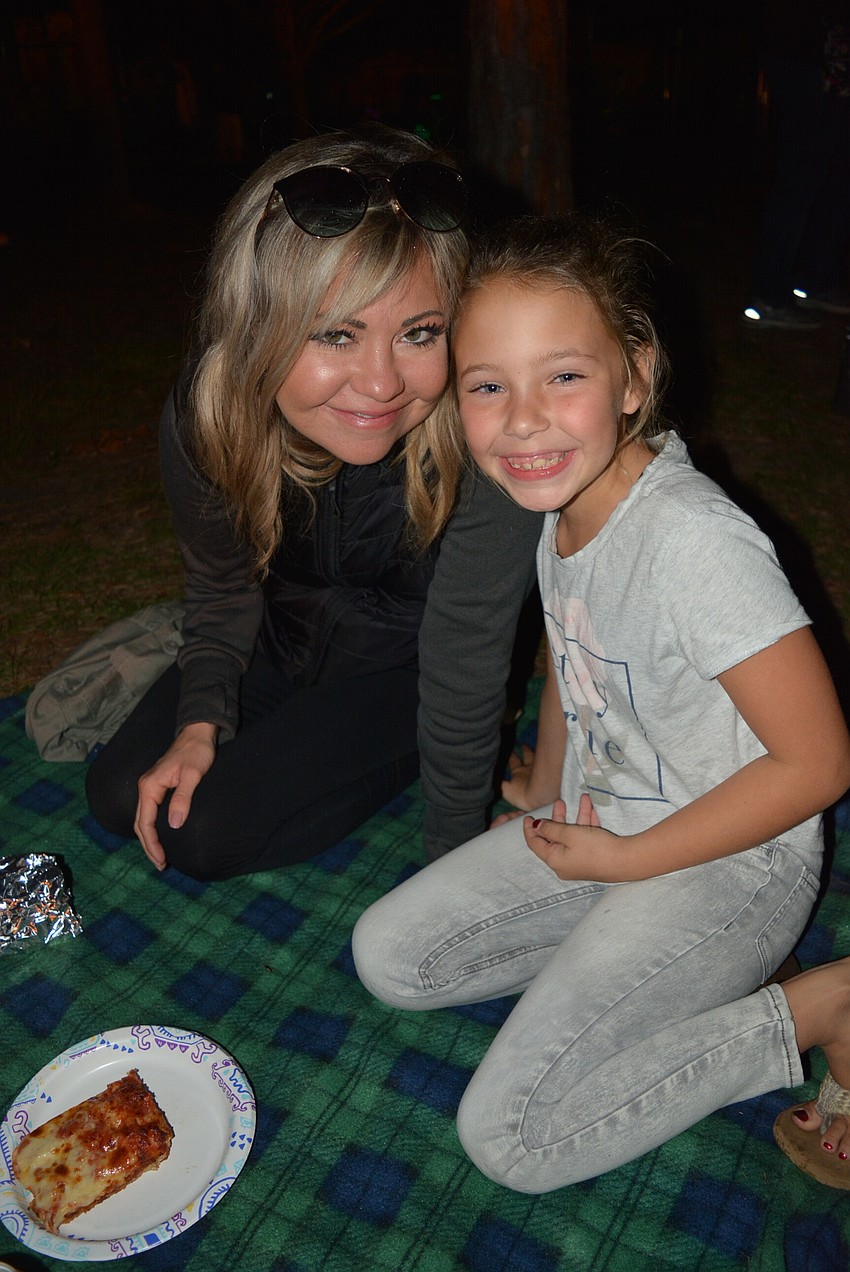 Jessica and Chloe Hoeper eat by the glow of the bonfire. It's their third year attending the event.