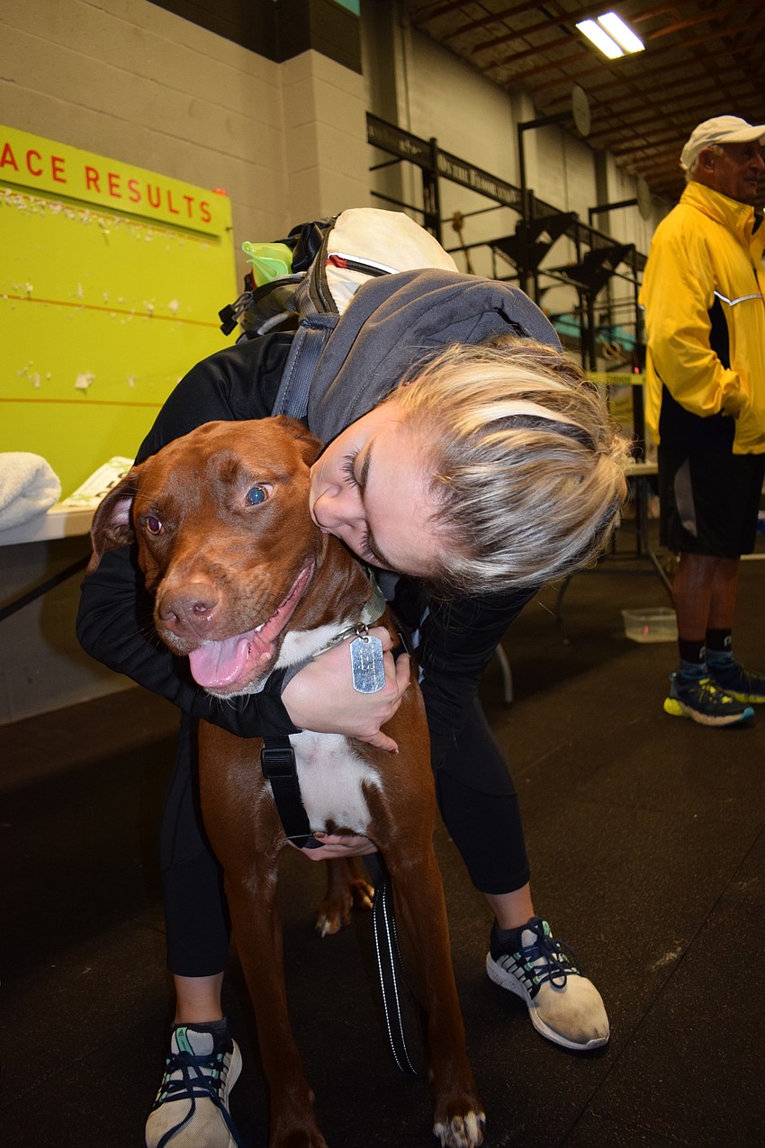Bradenton resident Kaitlyn Saum kisses her dog, Chevy. Chevy's hip dysplasia and knee problems didn't stop him from wanting to run in the 5K.