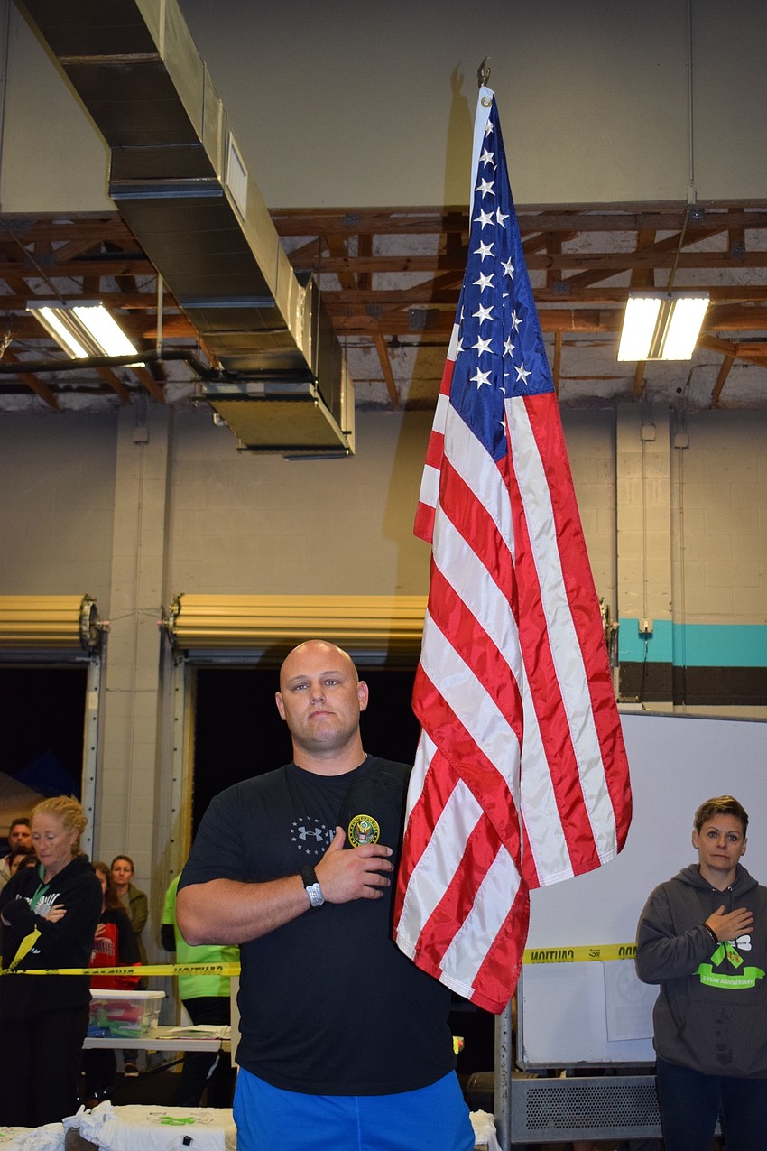 Palmetto's Lee Cosens holds the flag during the national anthem. Cosens served in the Army from 2007 to 2012.