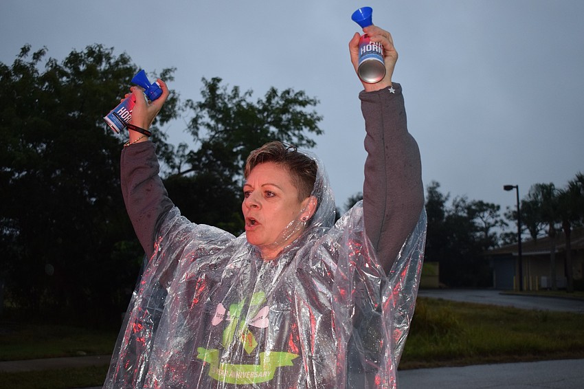 Monika Oberer, one of the race founders, blows an air horn to signify the beginning of the 5K run.