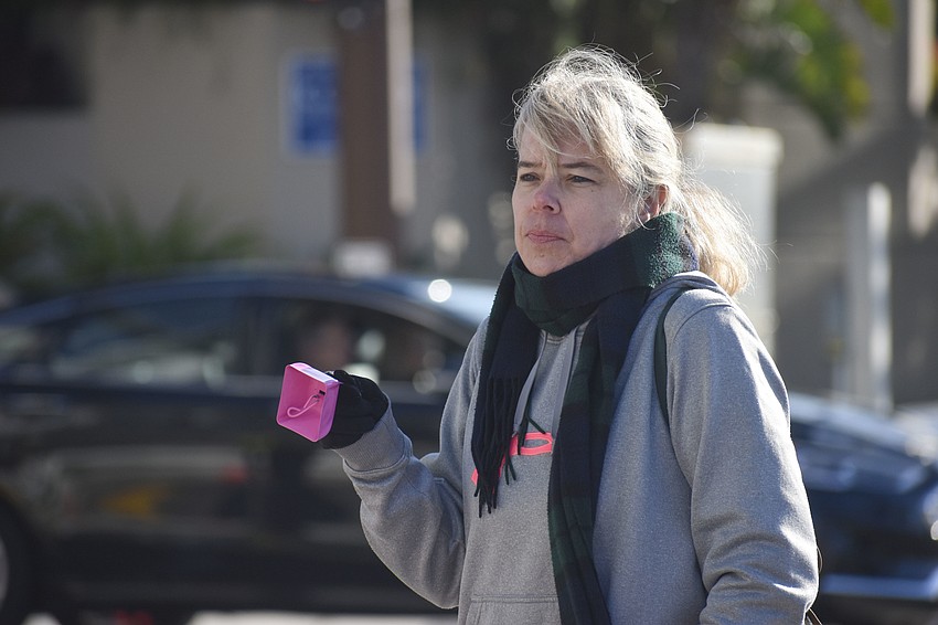 Sherri Skimerton rings a cowbell for the runners as they pass.