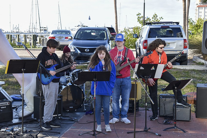 Students from the Music Compound perform beneath the Unconditional Surrender sculpture.