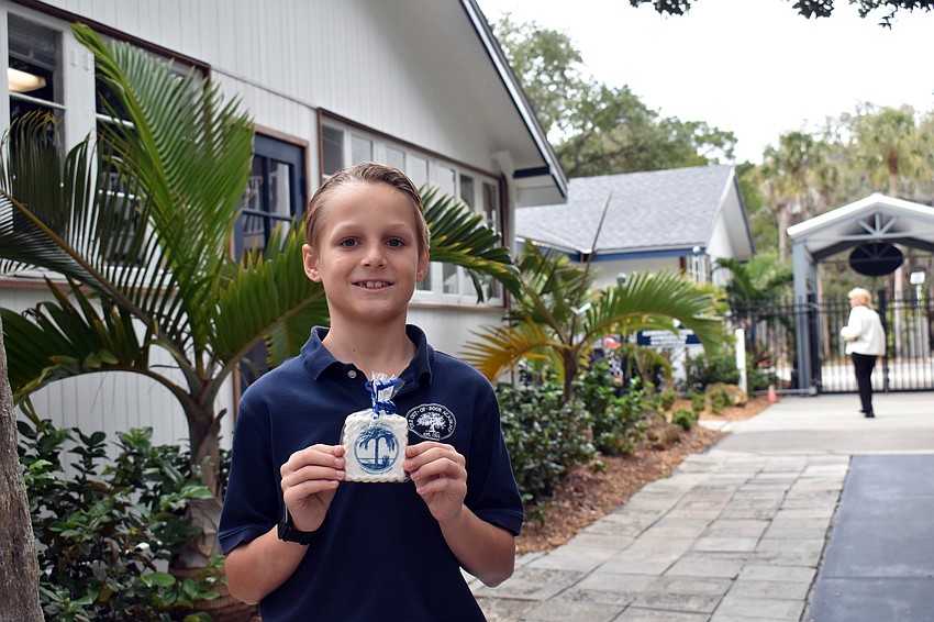 Third grade student Trudo Letschert is excited to eat his sugar cookie that features the school's original logo.