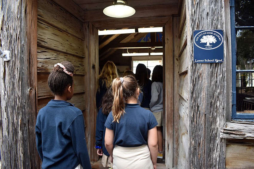 Students enter the campus' historic cabin.