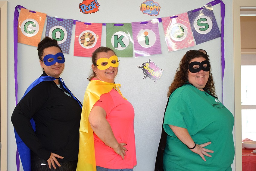 Sasha Lioce, Aleksandra Moore and Erika Rolando dress in masks and capes as part of their Girl Scout Cookie Delivery Day's superhero theme.
