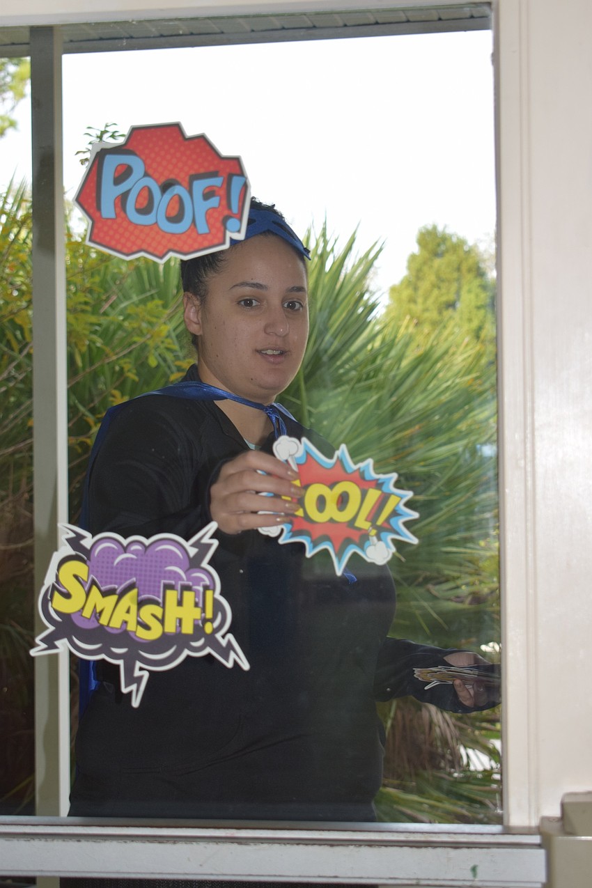 Sasha Lioce, product program manager for Girl Scouts of Gulfcoast Florida, decorates a building at Camp Honi Hanta for Girl Scout Cookie Delivery Day.