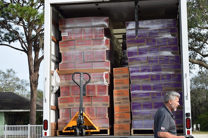 Large palettes of Girl Scout cookies are unloaded from one truck delivery.