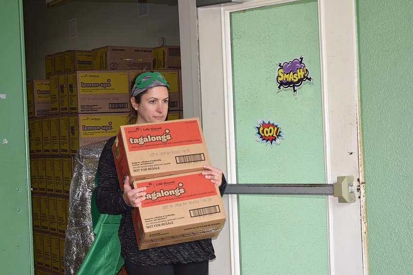 Victoria Cobb, leader of Girl Scout Troop 165, assists in loading Tagalongs into cars.