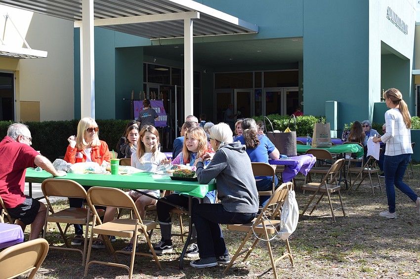 Grandparents adore their grandchildren while having lunch during Grandparents Day.
