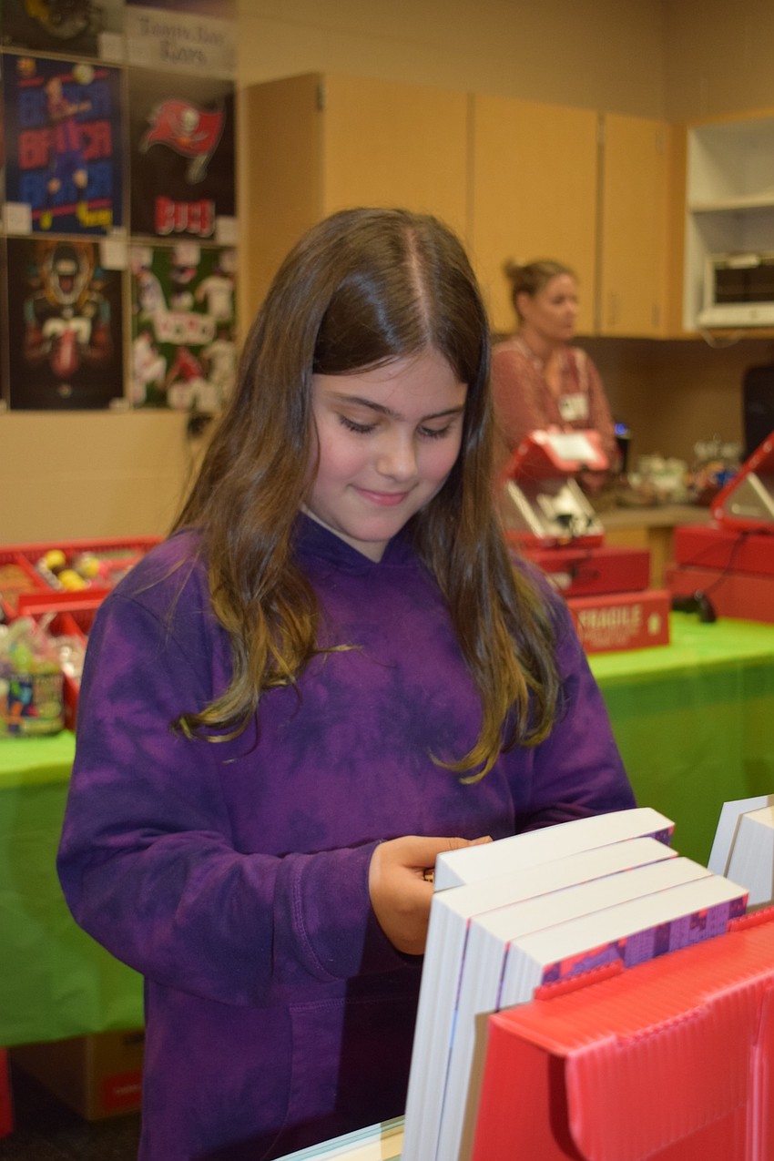 Hailey Padgett, a fifth grader, looks at the book selection during the book fair.