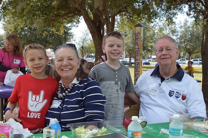 Oliver White, a first grader, enjoys lunch with his grandmother Shirley Easey, brother Charlie White, a third grader, and grandfather John Easy. Shirley Easey says they love going to the school for Grandparents Day every year.