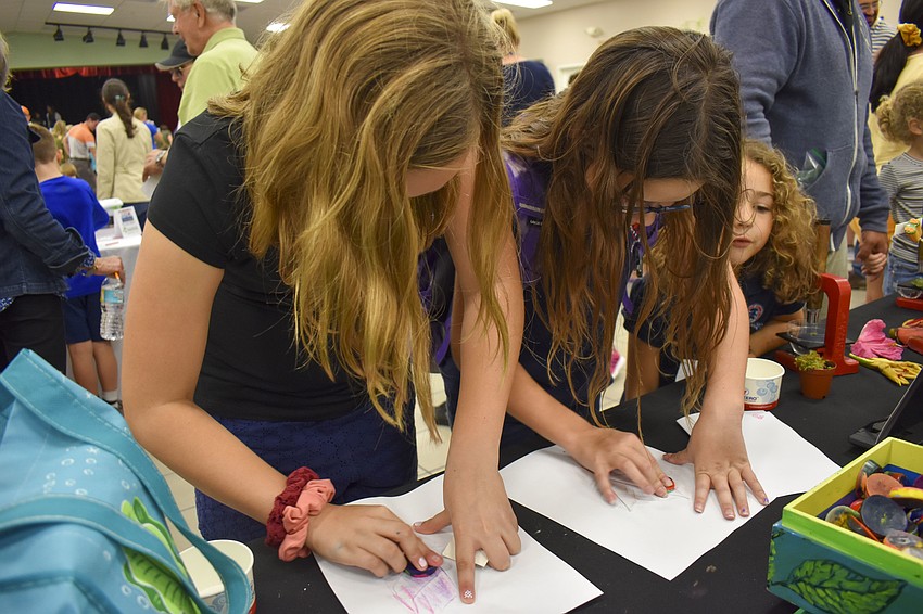 Addison Hankey, 11, and Lily Glaubach, 11, create their leaf rubbings.