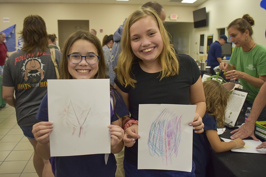 Lily Glaubach, 11, and Addison Hankey, 11,  show their leaf rubbings.