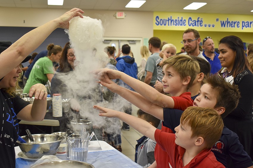 Zachary, 9, Adam, 7, and Nathan Ponte, 5, learn about nitrogen through a balloon experiment.